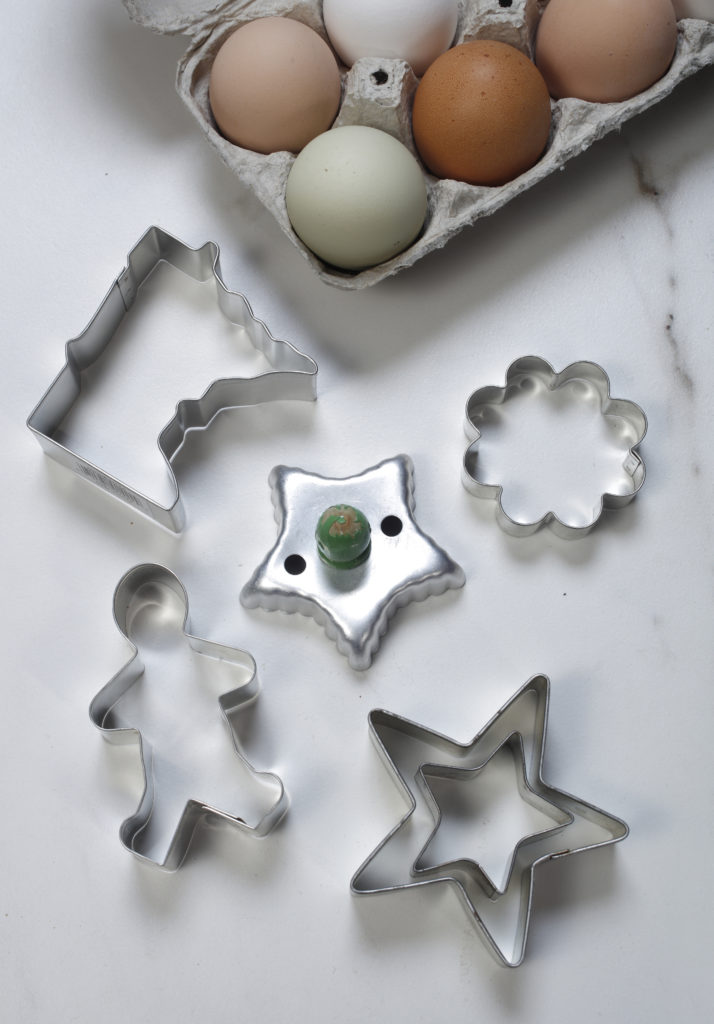 Eggs and cookie cutters in various shapes: Minnesota, gingerbread person,stars, flower